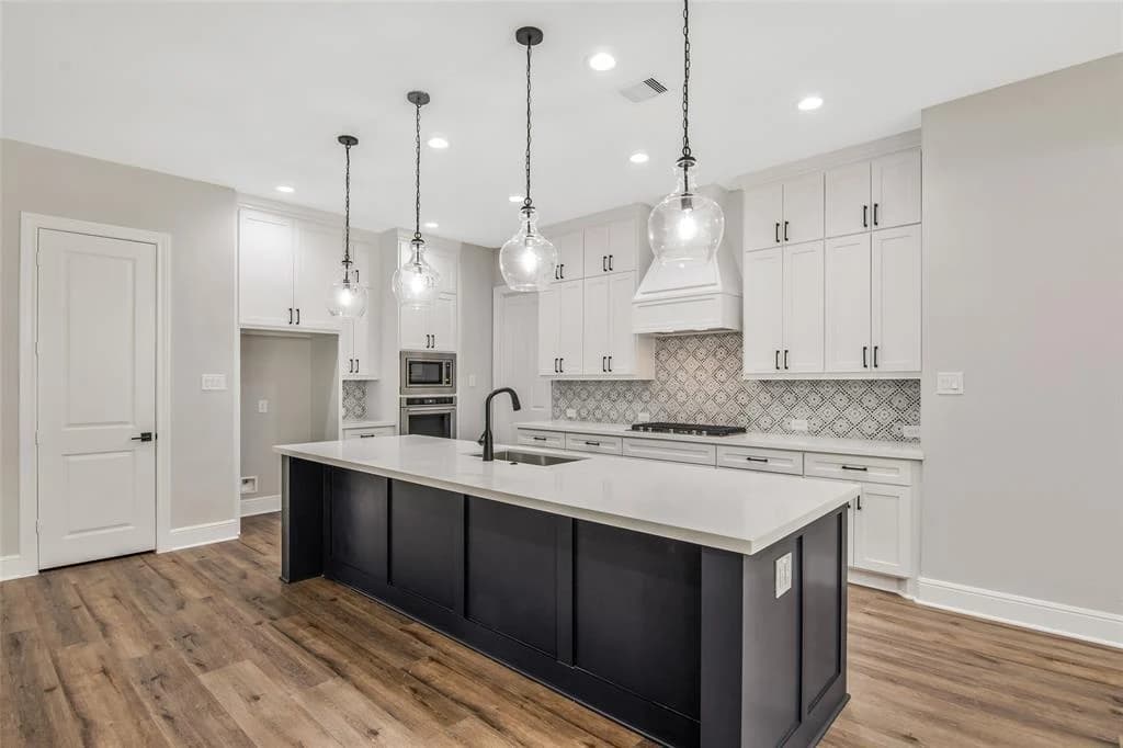 Kitchen with a large island, pendant lighting, and custom cabinetry